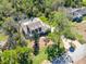 Aerial view of a two-story home with screened pool, surrounded by lush landscaping and trees at 405 Apache Trl, Brandon, FL 33511