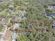 An aerial view showcases a spacious lot surrounded by lush greenery and neighborhood scenery at 405 Apache Trl, Brandon, FL 33511