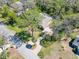 Aerial view of a home surrounded by lush trees, featuring a pool and a brick paver driveway at 405 Apache Trl, Brandon, FL 33511