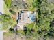 Aerial view of a home with a pool, paver driveway, and surrounded by lush trees at 405 Apache Trl, Brandon, FL 33511