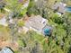 Aerial view of a home with a screened pool, lush greenery, and a brick paver driveway at 405 Apache Trl, Brandon, FL 33511