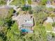Aerial view of a home featuring a pool, lush landscaping, and a unique brick paver driveway at 405 Apache Trl, Brandon, FL 33511