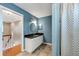 Well-lit blue bathroom featuring a granite countertop, modern fixtures, and a shower with striped curtain at 405 Apache Trl, Brandon, FL 33511