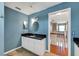 Bright blue bathroom with a granite countertop, modern fixtures, and a view of the staircase at 405 Apache Trl, Brandon, FL 33511