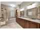Luxurious bathroom with double sinks, granite countertops, wood cabinets, soaking tub, and walk-in shower at 405 Apache Trl, Brandon, FL 33511