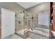 Elegant bathroom featuring a glass-enclosed shower, soaking tub, and neutral tile flooring at 405 Apache Trl, Brandon, FL 33511