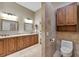 Stylish bathroom featuring a double sink vanity, wood cabinets, and a separate toilet area at 405 Apache Trl, Brandon, FL 33511