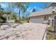 Expansive brick driveway, basketball hoop and manicured landscaping complement the home's exterior at 405 Apache Trl, Brandon, FL 33511