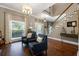 Inviting foyer with hardwood floors, staircase, elegant lighting, and views of the front door at 405 Apache Trl, Brandon, FL 33511