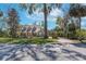 Charming home featuring a welcoming front porch, lush landscaping, and a brick driveway leading to the garage at 405 Apache Trl, Brandon, FL 33511