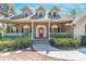 Inviting home with a red front door, a charming porch, and beautifully landscaped front yard at 405 Apache Trl, Brandon, FL 33511