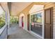 Charming front porch with white columns, lush greenery, and a glimpse of the welcoming red front door at 405 Apache Trl, Brandon, FL 33511