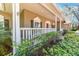 A cozy front porch framed by white railings and lush greenery, with a glimpse of the home's charming details at 405 Apache Trl, Brandon, FL 33511