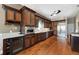 Gourmet kitchen featuring dark wood cabinetry, stainless steel appliances, wine rack, and hardwood flooring at 405 Apache Trl, Brandon, FL 33511
