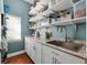 Well-organized laundry room featuring white cabinets, granite countertops, a stainless steel sink, and ample storage space at 405 Apache Trl, Brandon, FL 33511