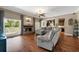 Open living room with hardwood floors, fireplace, a gray sectional sofa, and natural lighting at 405 Apache Trl, Brandon, FL 33511