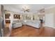 Spacious living room featuring hardwood floors, gray sectional sofa, open to kitchen, and abundant natural light at 405 Apache Trl, Brandon, FL 33511