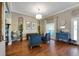 Cozy living room featuring two blue armchairs, hardwood floors, and elegant chandelier lighting at 405 Apache Trl, Brandon, FL 33511