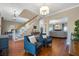 Bright living room showcasing hardwood floors, staircase, elegant chandelier lighting, and comfortable armchairs at 405 Apache Trl, Brandon, FL 33511