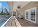 Relaxing covered patio with ceiling fans, a comfortable outdoor seating area, and views of the pool and surrounding landscape at 405 Apache Trl, Brandon, FL 33511