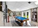 Recreation room boasts a pool table and doors opening to the lush backyard at 405 Apache Trl, Brandon, FL 33511