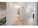 Hallway view showcasing wood-look tile flooring, bathroom entrance, and view into the kitchen at 4215 Hollow Stump Run, Palmetto, FL 34221