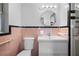 Well-lit bathroom features a modern vanity, circular mirror, and retro black and pink tile at 4630 W Bay Villa Ave, Tampa, FL 33611