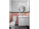 Bathroom features a modern vanity and toilet with circular mirror and retro black and pink tile at 4630 W Bay Villa Ave, Tampa, FL 33611