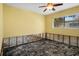Bright, yellow bedroom with ceiling fan needs renovation but has lots of natural light at 4630 W Bay Villa Ave, Tampa, FL 33611