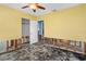 Bedroom with damage has ceiling fan and closet with connecting door to another room at 4630 W Bay Villa Ave, Tampa, FL 33611