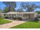 Charming single-story home with a brick pathway, manicured lawn, carport, and beautiful landscaping at 4630 W Bay Villa Ave, Tampa, FL 33611