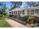 Charming single-story home featuring a well-manicured lawn, mature trees, and front garden at 4630 W Bay Villa Ave, Tampa, FL 33611