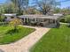 Charming single-story home with a well-manicured lawn and a brick paver walkway at 4630 W Bay Villa Ave, Tampa, FL 33611