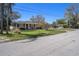 A street view of a single-story home with a well-manicured lawn, mature trees, and a front yard at 4630 W Bay Villa Ave, Tampa, FL 33611