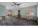 Bright living room offering window light and ceiling fan with damage to the bottom of walls needing to be repaired at 4630 W Bay Villa Ave, Tampa, FL 33611