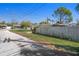 Street view with wooden fence, vibrant greenery, and clear sky showcasing the neighborhood's serene atmosphere at 4630 W Bay Villa Ave, Tampa, FL 33611