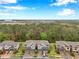 Aerial view of townhomes with lush green landscape and an airport in the background at 5086 San Martino Dr, Wesley Chapel, FL 33543