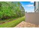 Home's backyard with partial fencing, landscaping, and wooded views at 5086 San Martino Dr, Wesley Chapel, FL 33543