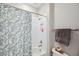 Bright bathroom featuring a bathtub with a leaf-patterned shower curtain and tiled walls at 5086 San Martino Dr, Wesley Chapel, FL 33543