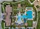 Overhead view of community water park, which includes a pool, waterslide, cabanas, grass lawn and clubhouse at 5086 San Martino Dr, Wesley Chapel, FL 33543