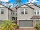 Charming townhome featuring a gray exterior, brick driveway, and a well-manicured lawn, creating a welcoming curb appeal at 5086 San Martino Dr, Wesley Chapel, FL 33543