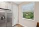 Stainless fridge shown next to a large bright window with a verdant view at 5086 San Martino Dr, Wesley Chapel, FL 33543