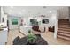 Open-concept living room with hardwood floors, stairs, and a large TV for a cozy atmosphere at 5086 San Martino Dr, Wesley Chapel, FL 33543