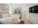 The main bedroom features a tray ceiling, a TV and large windows with a backyard view at 5086 San Martino Dr, Wesley Chapel, FL 33543