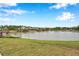 Scenic pond view with grass lawn, fountain feature, and lush landscaping at 5086 San Martino Dr, Wesley Chapel, FL 33543