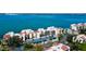 Aerial view of white condominiums, parking, and landscaping along the water at 5729 Puerta Del Sol Boulevard South # 486, St Petersburg, FL 33715