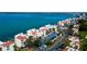 Aerial view of white condominiums with red roofs, parking and lush landscaping at 5729 Puerta Del Sol Boulevard South # 486, St Petersburg, FL 33715
