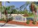 Elegant community sign at the entrance surrounded by landscaping and palm trees at 5729 Puerta Del Sol Boulevard South # 486, St Petersburg, FL 33715
