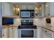 Kitchen with stainless steel appliances, tile backsplash, and glass-front cabinets at 5729 Puerta Del Sol Boulevard South # 486, St Petersburg, FL 33715
