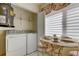 Functional laundry area with a washer, dryer, storage, and a small dining area at 5729 Puerta Del Sol Boulevard South # 486, St Petersburg, FL 33715